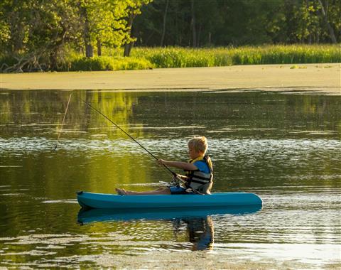 Child fishing on a river with a life jacket