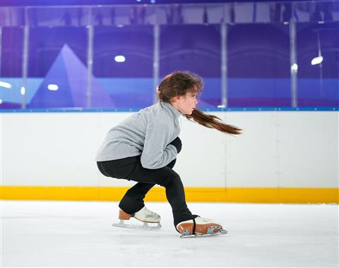 Girl ice skating in an indoor ice skating rink