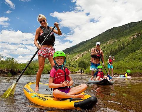 Family paddle boarding together on a river