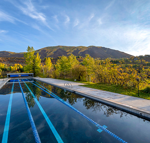 lap pool surrounded by trees with fall leaves