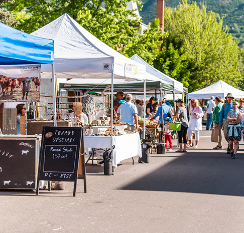 Farmers market with various booths and people shopping