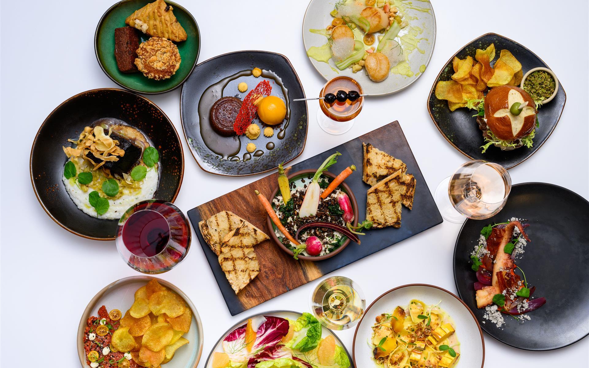 Large food spread with drinks, shareables, and main dishes