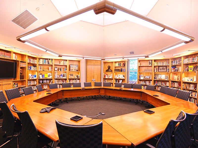 Paepcke Library with hexagon-shaped chandelier and table with open area in center and a television for presentations