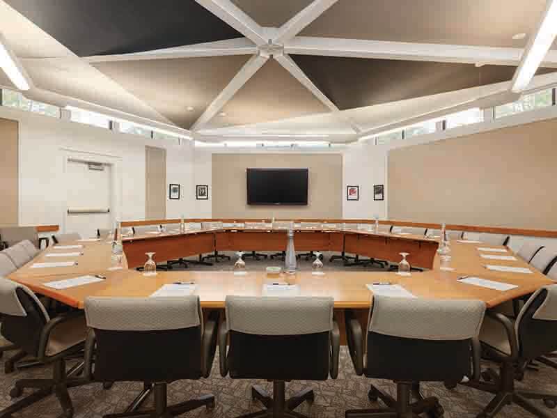 Stranahan Room with hexagon-shaped table setup and open area in the center as well as a television for presentations